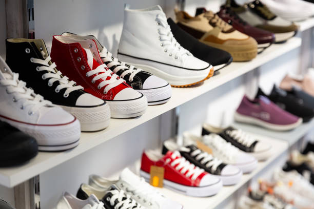 Различные стили кроссовок Converse выставлены на полках обувного магазина.