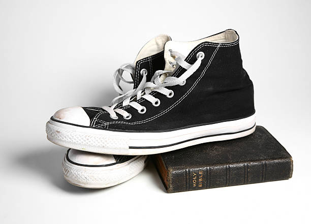 Классические черные кроссовки Converse, помещенные на старую книгу, подчеркивают их вневременную американскую привлекательность.